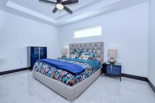 a bedroom with a bed and a ceiling fan at New listing - Amazing new 3beds/3baths Gulf access villa w. heated pool and outdoor kitchen! in Matlacha