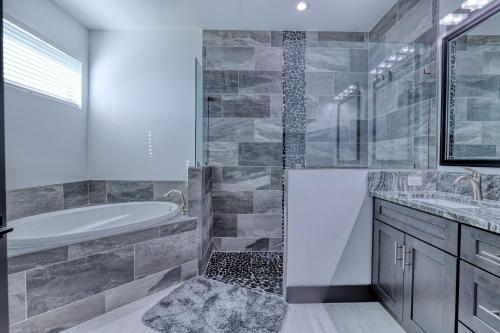 a bathroom with a tub and a shower and a sink at New listing - Amazing new 3beds/3baths Gulf access villa w. heated pool and outdoor kitchen! in Matlacha