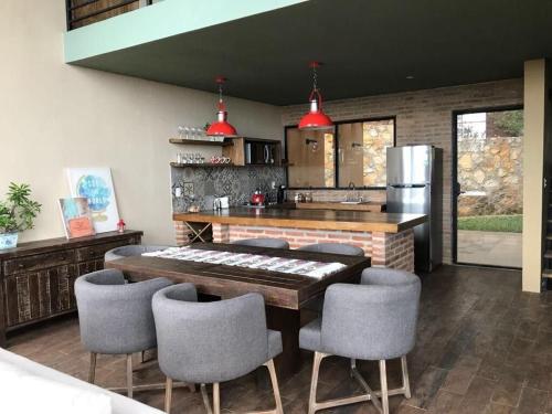 una cocina con mesa y algunas sillas. en Mágica casa en las Nubes, San Cristóbal, en San Cristóbal de Las Casas