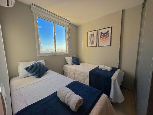 a bedroom with two beds and a window at Duplex Penthouse with Jacuzzi and Private BBQ in Itaparica