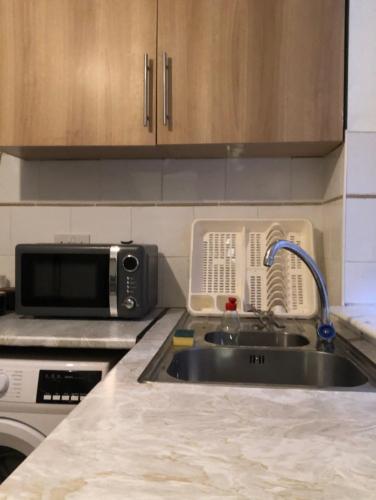 a kitchen with a sink and a microwave at Tatia House in Gainsborough