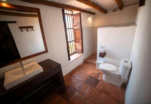 a bathroom with a sink and a toilet and a mirror at Achiotte by Masaya in Barichara