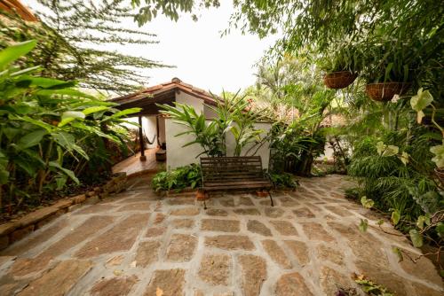 a patio with a bench in a garden at Achiotte by Masaya Collection in Barichara
