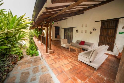 a patio with couches and chairs on a house at Achiotte by Masaya Collection in Barichara
