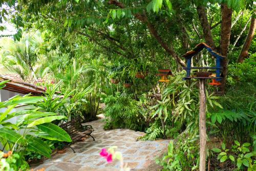 a garden with a blue bird house on a tree at Achiotte by Masaya Collection in Barichara