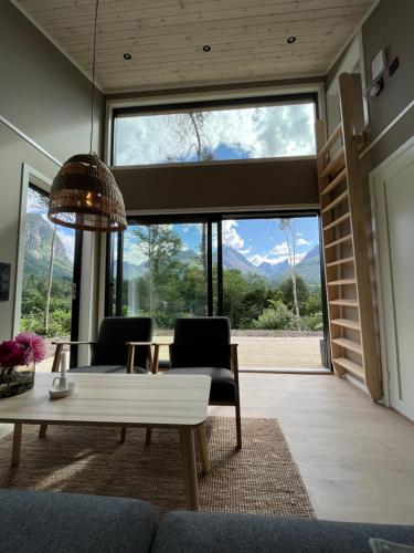 a living room with a table and chairs and a large window at Kavliskogen panorama in Isfjorden