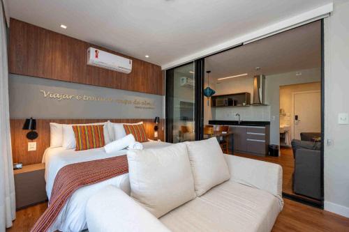 una camera con un grande letto e un divano di Wanderlust Experience Hotel BW Signature Collection OFICIAL a Campos do Jordão