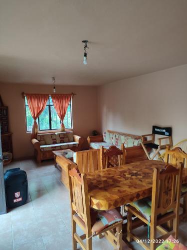 a living room with a wooden table and chairs at Casa YilZil in Alpuyeca