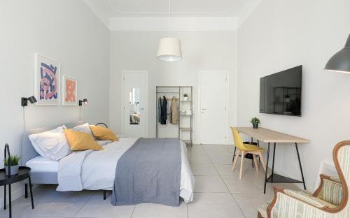 Casa Doclea _Comfort & relax nel cuore della città في نابولي: غرفة نوم بسرير ومخدات صفراء وطاولة