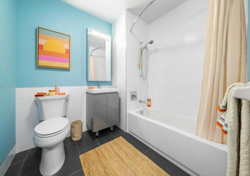 a bathroom with a white toilet and a bath tub at Glorious 3 Bed 2 Bath In Upper East Side in New York