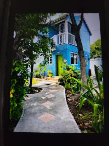 a blue house with a yellow door and a walkway at Casa Catalina in San Pedro