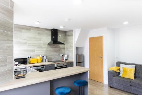 a kitchen with a counter and a couch in a room at Modern Apartments Near Cardiff City Centre in Cardiff