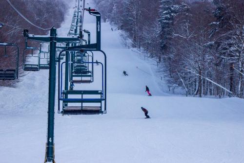 un grupo de personas esquiando por un remonte en Smugglers' Notch Resort Private Suites, en Cambridge