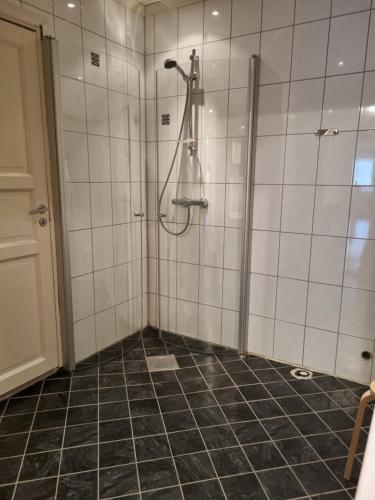 baño con ducha de azulejos negros en Stor leilighet med 4 senger sentralt i Førde, en Førde