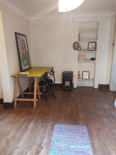 Una habitación con un escritorio con una pintura. en Lastarrias centrico - Bohemio, en Santiago