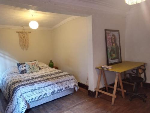 a bedroom with a bed and a table with a desk at Lastarrias centrico - Bohemio in Santiago