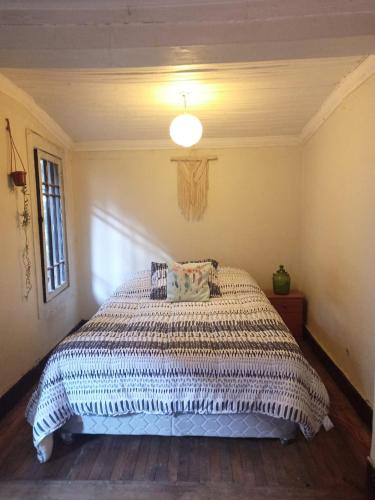 1 dormitorio con 1 cama con edredón blanco en Lastarrias centrico - Bohemio en Santiago