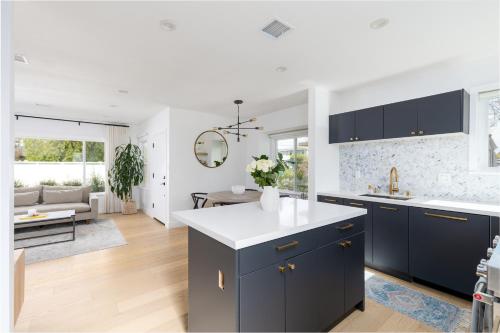 eine Küche mit blauen Schränken und ein Wohnzimmer in der Unterkunft Beautiful 3 bedroom in Mar Vista in Los Angeles