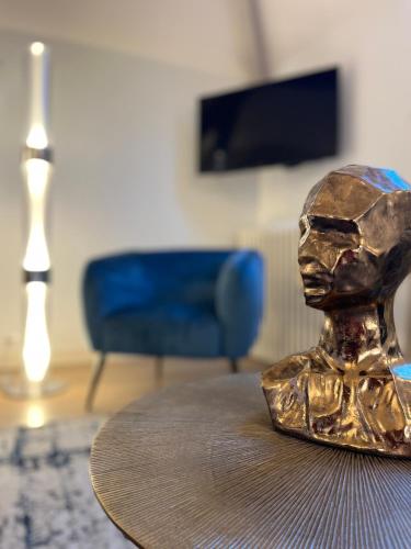 a bronze statue sitting on a table in a living room at Richard Lequet Domaine gastronomique du Val d Atur in Boulazac