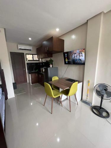 a kitchen with a wooden table and yellow chairs at Eden’s Residence Space Rental in Cagayan de Oro