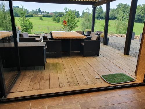 a patio with a table and chairs on a deck at au grain de folie in Lubersac