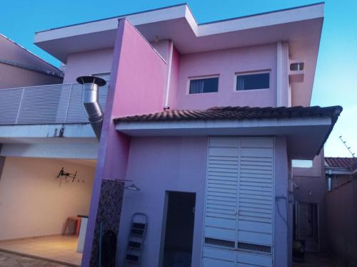 una casa rosa con garaje en Casa Sobrado Alto Padrão Charme e Conforto, en Ribeirão Preto