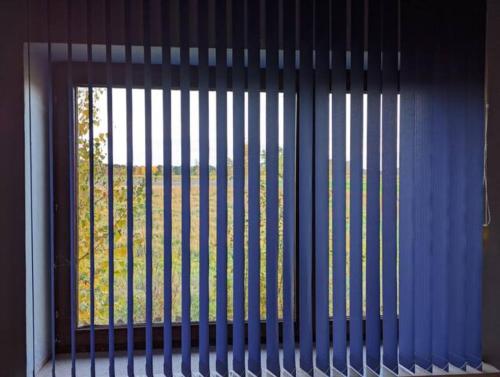 a window with vertical blinds on it with a view of a field at Grosse Wohnung in Top-Lage in Langwedel (BREMEN) in Langwedel