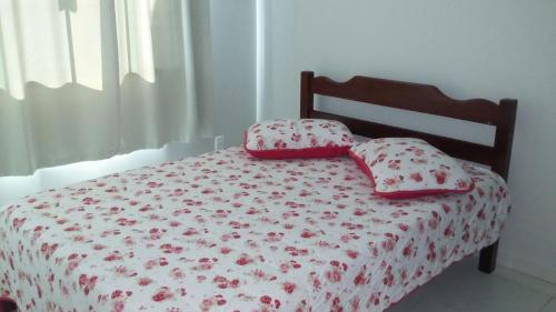 Casa Bombinhas temporada في بومبينهاس: غرفة نوم عليها سرير ووسادتين