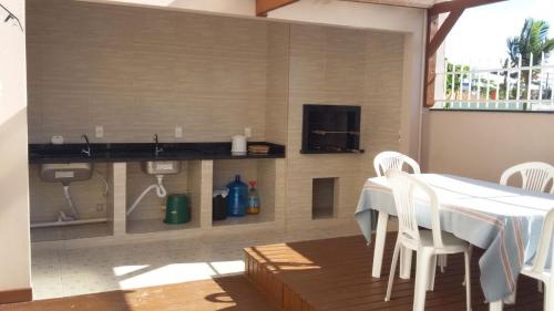 una sala da pranzo con tavolo, sedie e TV di Casa Bombinhas temporada a Bombinhas