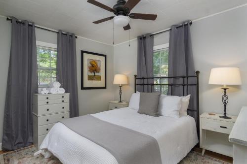 um quarto com uma cama e uma ventoinha de tecto em Charming Pet-Friendly Cottage Walkable to Town! em Black Mountain