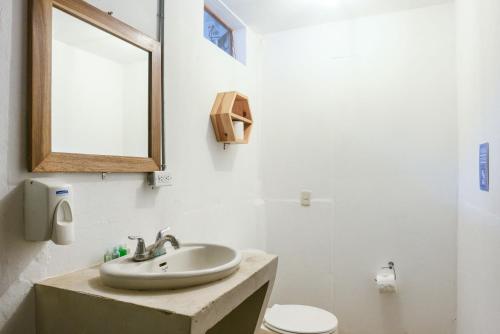 uma casa de banho com um lavatório, um espelho e um WC. em Selina Maderas em San Juan del Sur