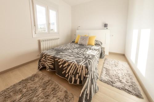 a bedroom with a bed with a zebra blanket and two rugs at Piso en el puerto con vistas al Mar+Wifi+ SmartTv in Burela de Cabo