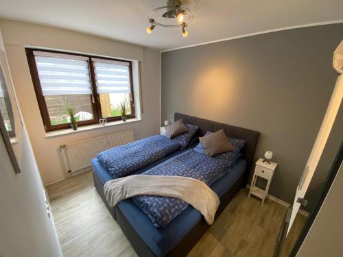 1 dormitorio con cama con sábanas azules y ventana en Ferienwohnung im Lipperland en Bad Salzuflen