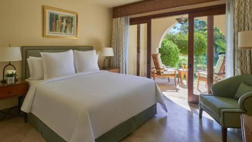 a bedroom with a large white bed and a patio at fourseasons resort - chalet- Private Residence at fourseasons sharm elsheikh in Sharm El Sheikh