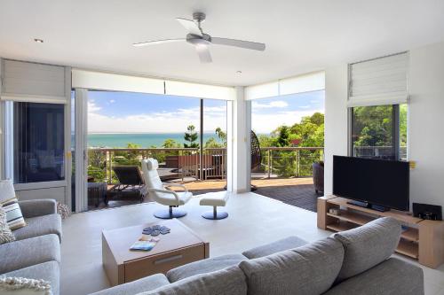 a living room with a couch and a television at Peppers Noosa Resort and Villas in Noosa Heads