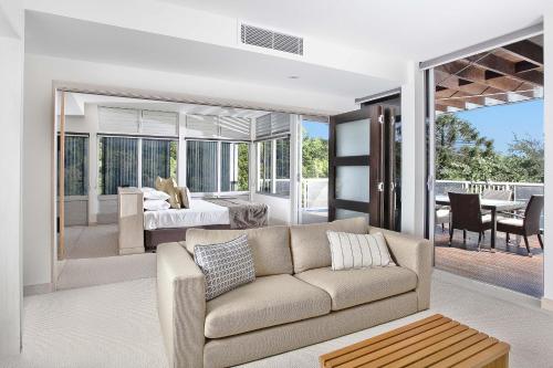 a living room with a couch and a bedroom at Peppers Noosa Resort and Villas in Noosa Heads
