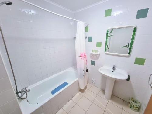 un bagno con una vasca bianca e un lavandino di Apartamento Sol e Praia - T2 na Praia de Monte Gordo a Monte Gordo