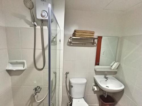 a bathroom with a shower and a toilet and a sink at Donser Studio in Bacolod