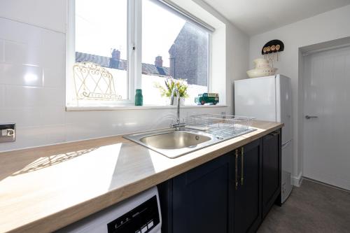 a kitchen with a sink and a refrigerator at Air Host and Stay - Earp House 3 bedroom, sleeps 7, mins from train in Liverpool