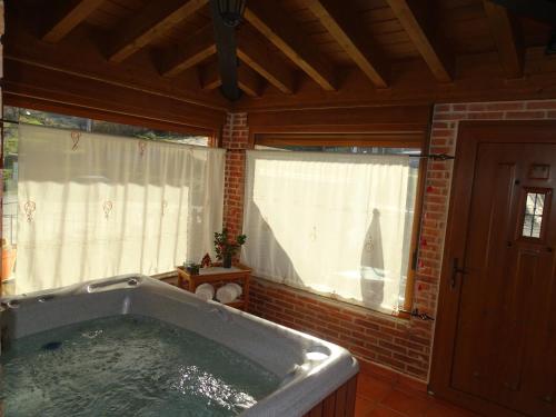 bañera grande en una habitación con ventana en ALTILLO DEL ARAVALLE, en Umbrías