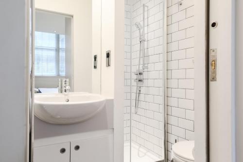 a white bathroom with a sink and a toilet at Olympic Park Apartments in London