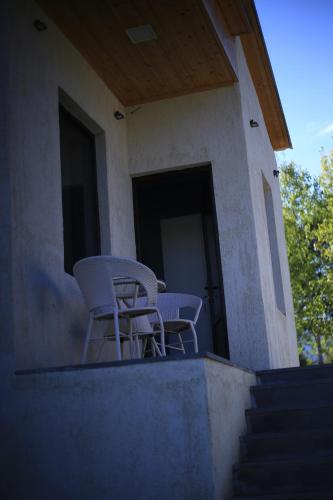 two chairs and a table on the porch of a house at Sunny Sadgeri in Borjomi
