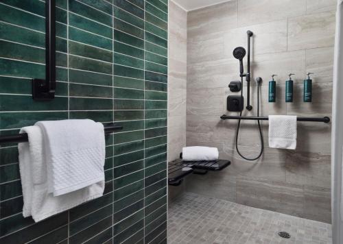 a bathroom with a shower with green tiles at Hilton Stockton in Stockton