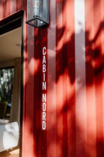 a red wall with a sign that saysatomichibition at Cozy Cabins I Tiny House Seecontainer in Hahnenklee-Bockswiese