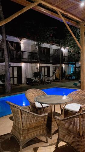a patio with a table and chairs next to a pool at Villa Albergaria in Flecheiras