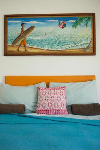 a picture of a man with a surfboard on the beach at LALORA Hotel & Villas in San Patricio Melaque