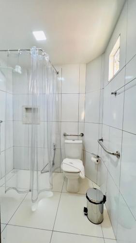 a white bathroom with a toilet and a shower at Hotel Pousada Kairos Manaira in João Pessoa
