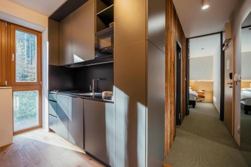 a kitchen with stainless steel appliances and a bedroom at ENDEMIT Boutique Hotel & Spa in Horní Bečva