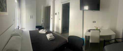 a room with a bed and a table and a desk at B&B UN POSTO AL MARE San Salvo Marina in San Salvo