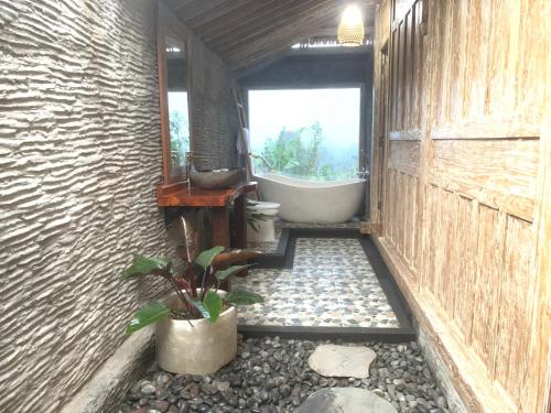 a bathroom with a tub and a toilet and a sink at JANE’S HOUSE & SPA BEDUGUL BALI in Patjung